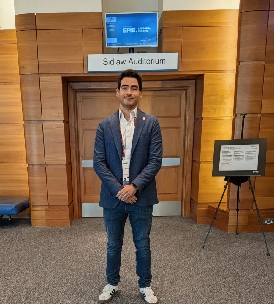 Man standing at the entrance of an auditorium with the SPIE sign above.
